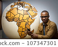 African man with a globe. Generated with AI 107347301