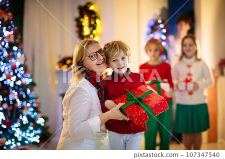 Family on Christmas day. Kids with gifts at door. Family on Christmas day. Kids with gifts at door. 107347540
