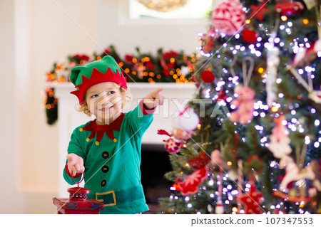 Child decorating Christmas tree. Kid on Xmas eve. Child decorating Christmas tree. Kid on Xmas eve. 107347553