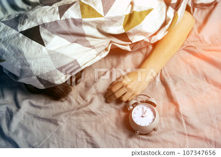 A young girl sleeps early in the morning under the blanket. A young girl sleeps early in the morning under the blanket. 107347656
