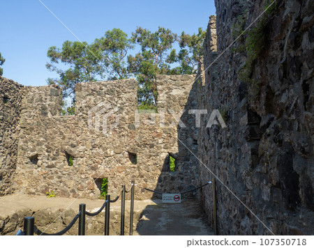 Remains of an old castle. Ancient fortifications made of stone. Museum in the open air. Medieval castle. Window in the wall. Remains of an old castle. Ancient fortifications made of stone. Museum in the open air. Medieval castle. Window in the wall. 107350718