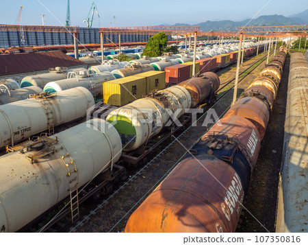 Railroad in the city against the backdrop of mountains.. Many railway paths. Wagons and trains on the tracks. unloading station. Tank wagons. Railroad in the city against the backdrop of mountains.. Many railway paths. Wagons and trains on the tracks. unloading station. Tank wagons. 107350816