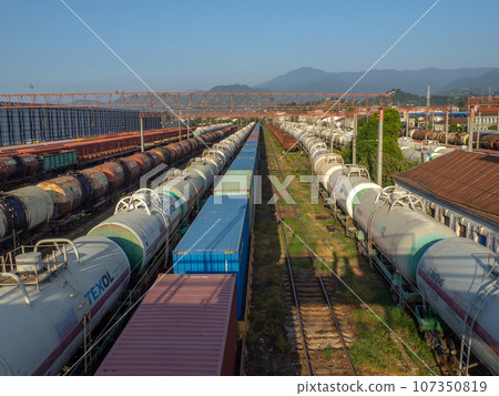 Railroad in the city against the backdrop of mountains.. Many railway paths. Wagons and trains on the tracks. unloading station. Tank wagons. Railroad in the city against the backdrop of mountains.. Many railway paths. Wagons and trains on the tracks. unloading station. Tank wagons. 107350819