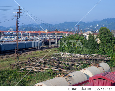 Railroad in the city against the backdrop of mountains. Many railway paths. Wagons and trains on the tracks. unloading station. Tank wagons. Batumi. Old metal structures. Railroad in the city against the backdrop of mountains. Many railway paths. Wagons and trains on the tracks. unloading station. Tank wagons. Batumi. Old metal structures. 107350852