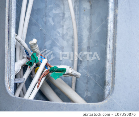 Wires inside. Wrapped contacts. Electrical safety. Electricity of the net. Sticking wires inside the pole Wires inside. Wrapped contacts. Electrical safety. Electricity of the net. Sticking wires inside the pole 107350876