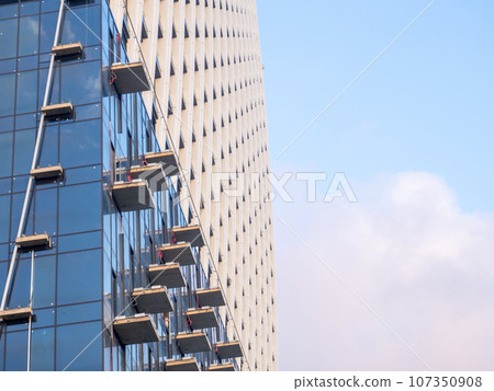 Part of a high-rise building under construction. End of construction. Finished works. Facade of a new beautiful skyscraper. Modern engineering. Part of a high-rise building under construction. End of construction. Finished works. Facade of a new beautiful skyscraper. Modern engineering. 107350908