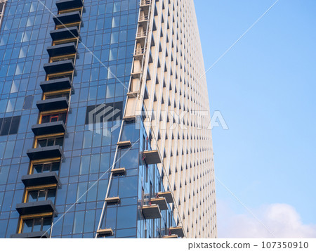 Part of a high-rise building under construction. End of construction. Finished works. Facade of a new beautiful skyscraper. Modern engineering. Part of a high-rise building under construction. End of construction. Finished works. Facade of a new beautiful skyscraper. Modern engineering. 107350910