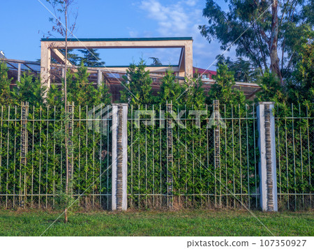 A fence made of rods and stacked stones. Zoo fence. A fence made of rods and stacked stones. Zoo fence. 107350927