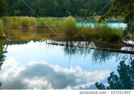 Clouds moving over the blue swamp and Goshikinuma in early autumn 107351997