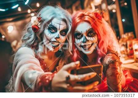 Girlfriends in Halloween costumes having fun and take selfies at the party Girlfriends in Halloween costumes having fun and take selfies at the party 107355317