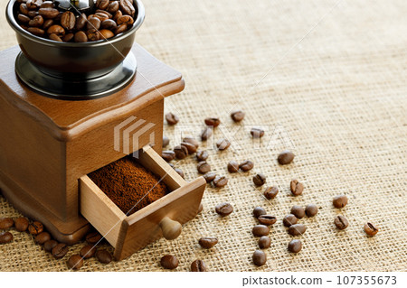 closeup of ground coffee and beans in manual grinder 107355673
