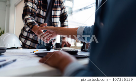 Two engineers shaking hand after working successful about brainstorming about construction project Two engineers shaking hand after working successful about brainstorming about construction project 107356139