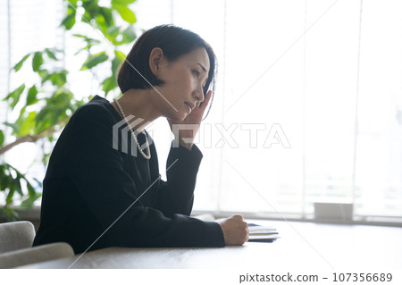 一名婦女在葬禮上哭泣的照片 107356689