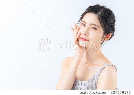 A middle-aged woman doing skin care against a white background A middle-aged woman doing skin care against a white background 107359175