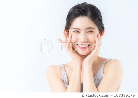 A middle-aged woman doing skin care against a white background 107359179