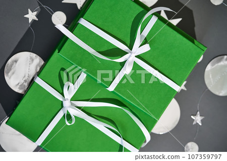 Green boxes with gifts on a gray. 107359797