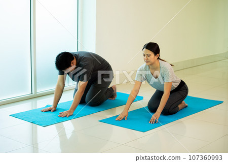 Two Asian young male and female adult kneeing for practice Yoga pose Two Asian young male and female adult kneeing for practice Yoga pose 107360993