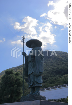 The statue of Shugyo Daishi and Mt. Gabaishi on the approach to Isshaka-ji Temple, the 73rd temple of the 88 Sacred Sites in Shikoku The statue of Shugyo Daishi and Mt. Gabaishi on the approach to Isshaka-ji Temple, the 73rd temple of the 88 Sacred Sites in Shikoku 107363288