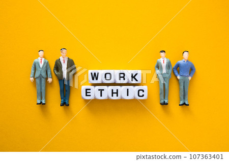 Miniature figure with Work ethic words on yellow background. Miniature figure with Work ethic words on yellow background. 107363401