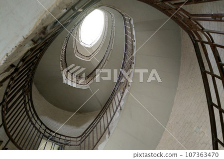 An old spiral staircase with an upward view. An old spiral staircase with an upward view. 107363470