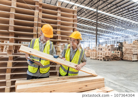 Team engineer carpenter wearing safety uniform and hard hat working holding clipboard checking. 107364304