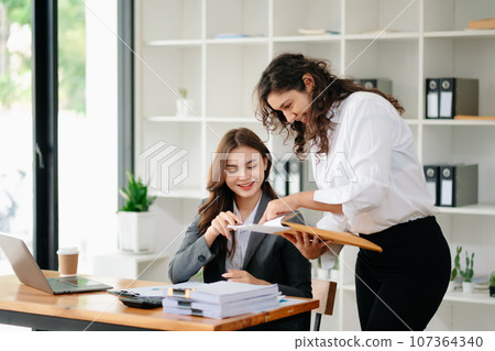 Portrait of success business people working together in home office. Couple teamwork startup concept. Portrait of success business people working together in home office. Couple teamwork startup concept. 107364340