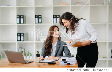 Portrait of success business people working together in home office. Couple teamwork startup concept. Portrait of success business people working together in home office. Couple teamwork startup concept. 107364342