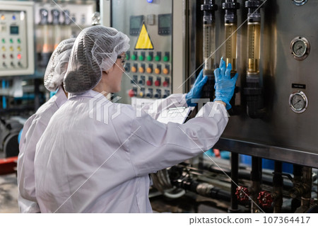 Female worker checking quality process of filtering cleanliness drinking water. Female worker checking quality process of filtering cleanliness drinking water. 107364417