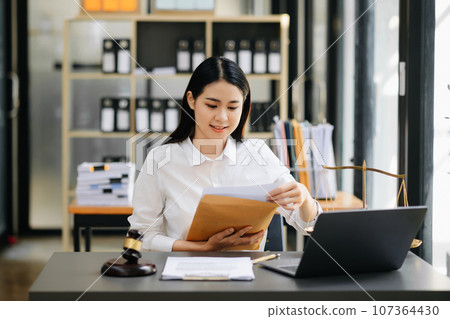 Beautiful asian woman lawyer working and gavel, tablet, laptop in front, Advice justice and law concept. 107364430