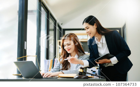 business Asian people and lawyers discussing contract papers sitting at the table. Concepts of law, advice, legal services. 107364733