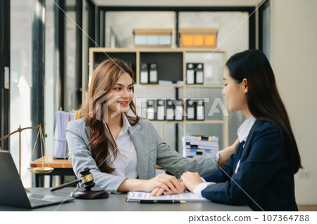 Business people compassionately holding hands and discussing contract papers with laptop and tabletat office Business people compassionately holding hands and discussing contract papers with laptop and tabletat office 107364788