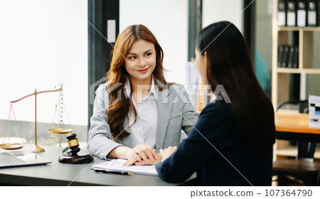 Business people compassionately holding hands and discussing contract papers with laptop and tabletat office 107364790