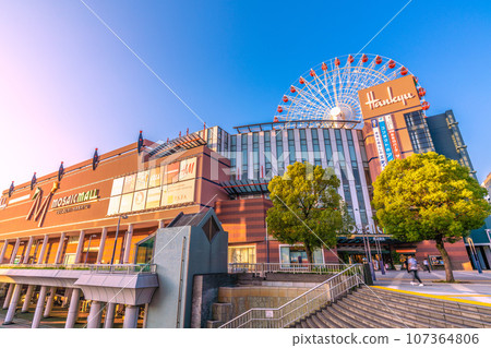 Yokohama cityscape, Japan, September. In front of Center Kita Station, view of the Ferris wheel and Tsuzuki Hankyu, etc., reflected in the blue sky and sunset Yokohama cityscape, Japan, September. In front of Center Kita Station, view of the Ferris wheel and Tsuzuki Hankyu, etc., reflected in the blue sky and sunset 107364806