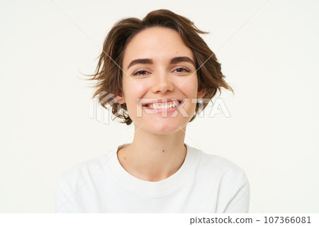 Close up portrait of brunette woman laughing and smiling, express genuine emotions, posing against white studio background 107366081
