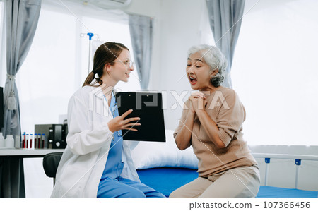 Caucasian doctor smiling take care of a young patient in hospital. Friendly nurse or therapeutic treat client Professional medical service concept. Caucasian doctor smiling take care of a young patient in hospital. Friendly nurse or therapeutic treat client Professional medical service concept. 107366456