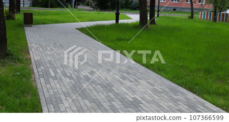 Part of the sidewalk made of tiles, green grass, pedestrian zone concept, road safety for people. 107366599