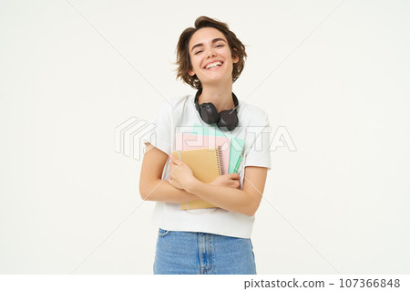 Image of carefree, smiling woman with notebooks, laughing and looking happy, posing over white background Image of carefree, smiling woman with notebooks, laughing and looking happy, posing over white background 107366848