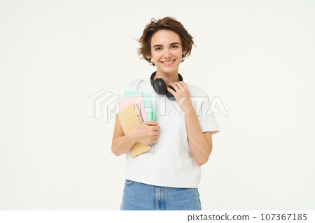 Image of stylish, modern girl student, holding workbook, documents. Woman teacher with papers standing over white background 107367185