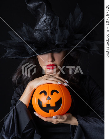 Witch with Halloween pumpkin 107367520