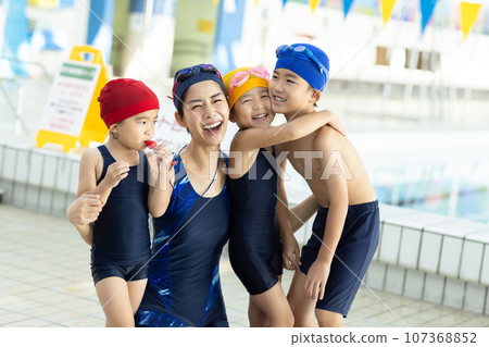 Children attending swimming school and their coach Children attending swimming school and their coach 107368852