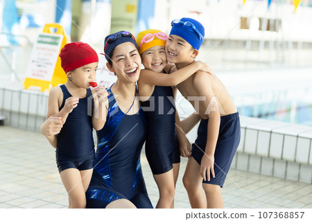 Children attending swimming school and their coach Children attending swimming school and their coach 107368857