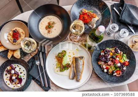 A set of Mediterranean cuisine dishes on a table in a restaurant. A set of Mediterranean cuisine dishes on a table in a restaurant. 107369588