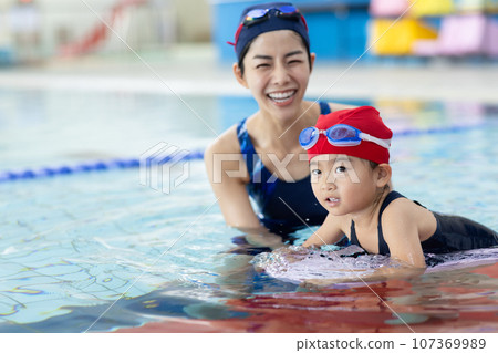 Children attending swimming school and their coach 107369989