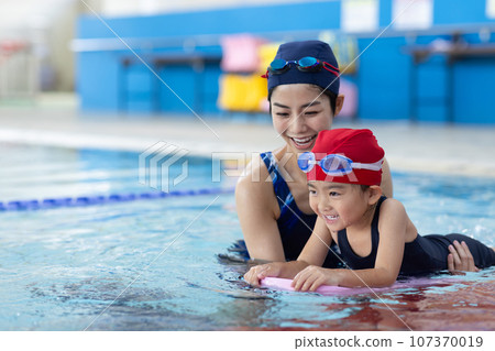 Children attending swimming school and their coach 107370019
