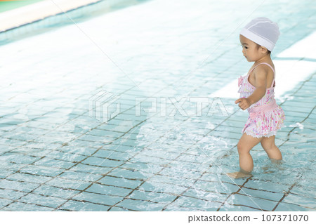 可愛的 1 歲女孩在泳池裡玩耍 107371070