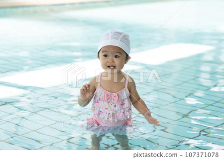 Cute 1 year old girl playing in the pool Cute 1 year old girl playing in the pool 107371078