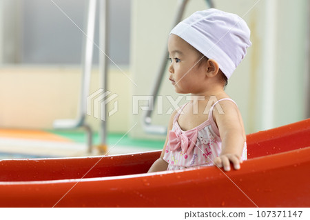 Cute 1 year old girl playing in the pool Cute 1 year old girl playing in the pool 107371147