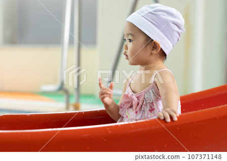 Cute 1 year old girl playing in the pool Cute 1 year old girl playing in the pool 107371148