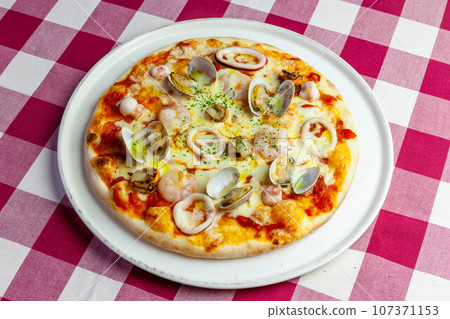 Pescatore pizza with plenty of seafood Pescatore pizza with plenty of seafood 107371153