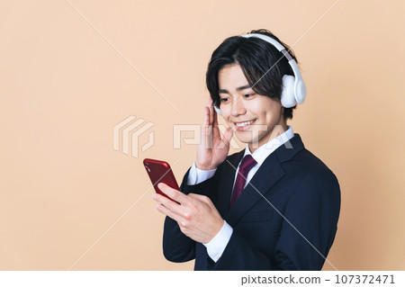 Man listening to music with headphones and smartphone 107372471